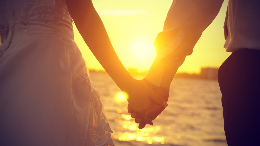 man-and-woman-holding-hands-in-sunset